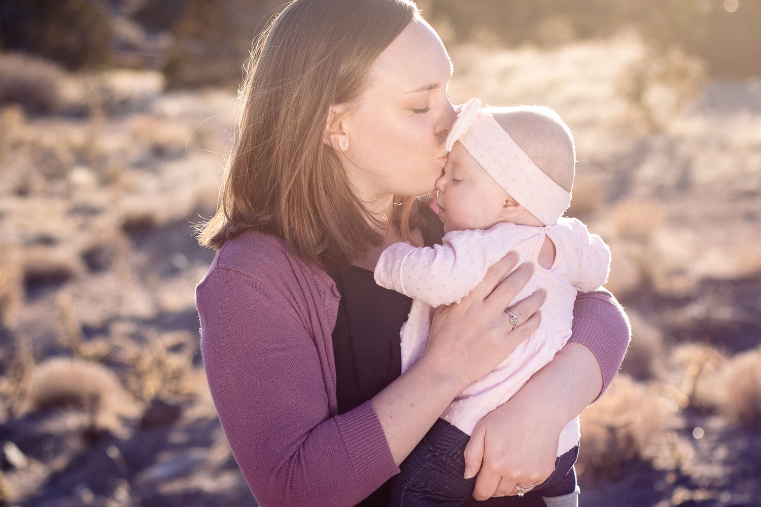 Beautiful outdoor family photography; mom kissing baby's head; Clarissa Anello