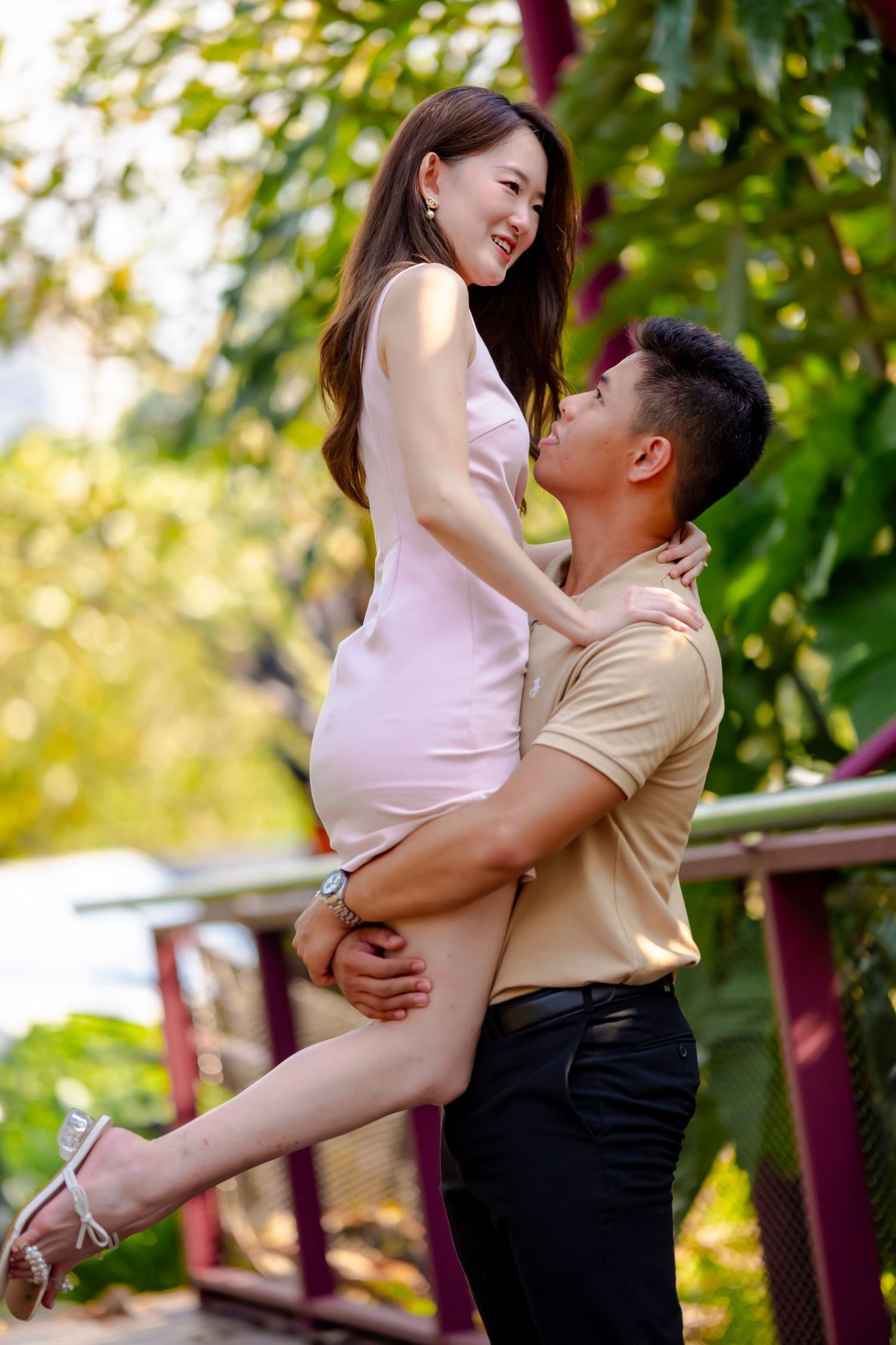 A couple in romantic embrace outdoors with natural sunlit background.