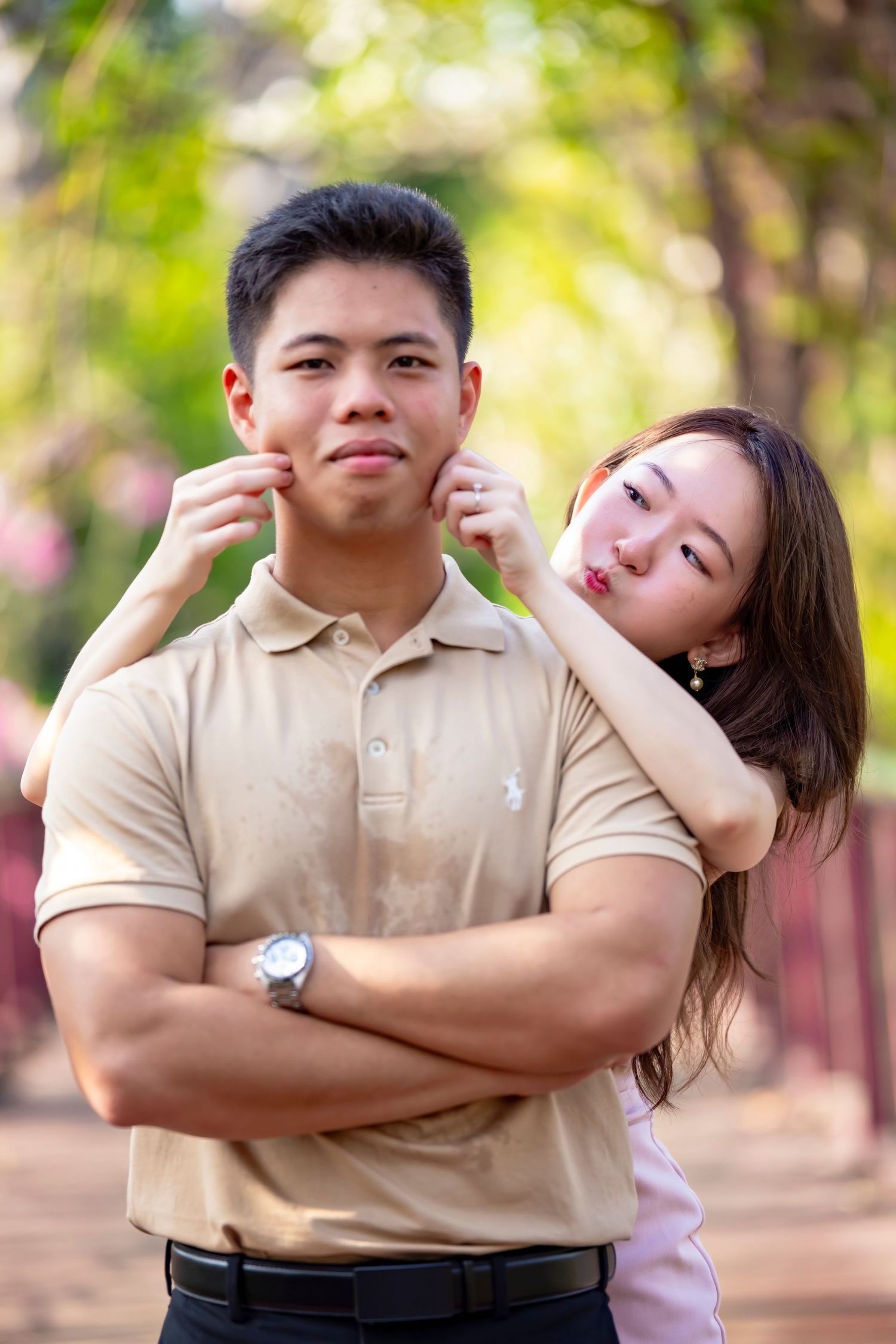 Playful couple in casual wear posing outdoors with teasing expressions.