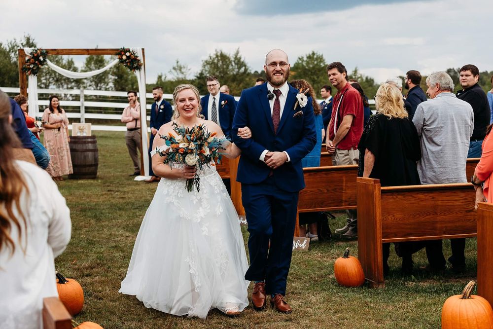 outdoor fall ceremony with bride and groom walking during recessional