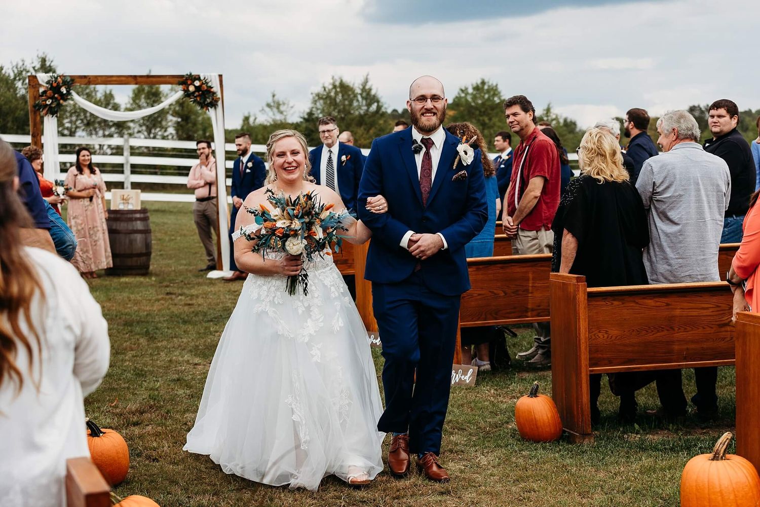 outdoor fall ceremony with bride and groom walking during recessional