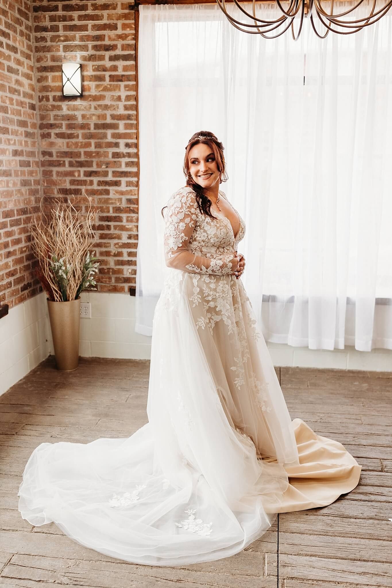 bride getting ready in bridal suite with wedding dress on