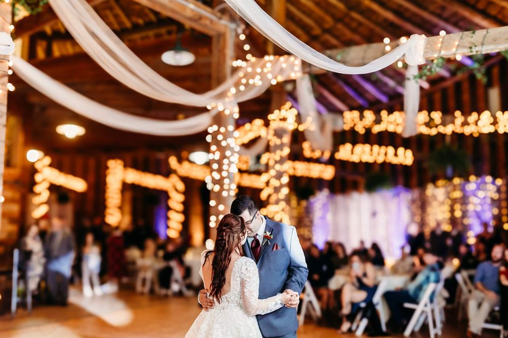 bride and groom sharing their first dance in a wedding barn venue