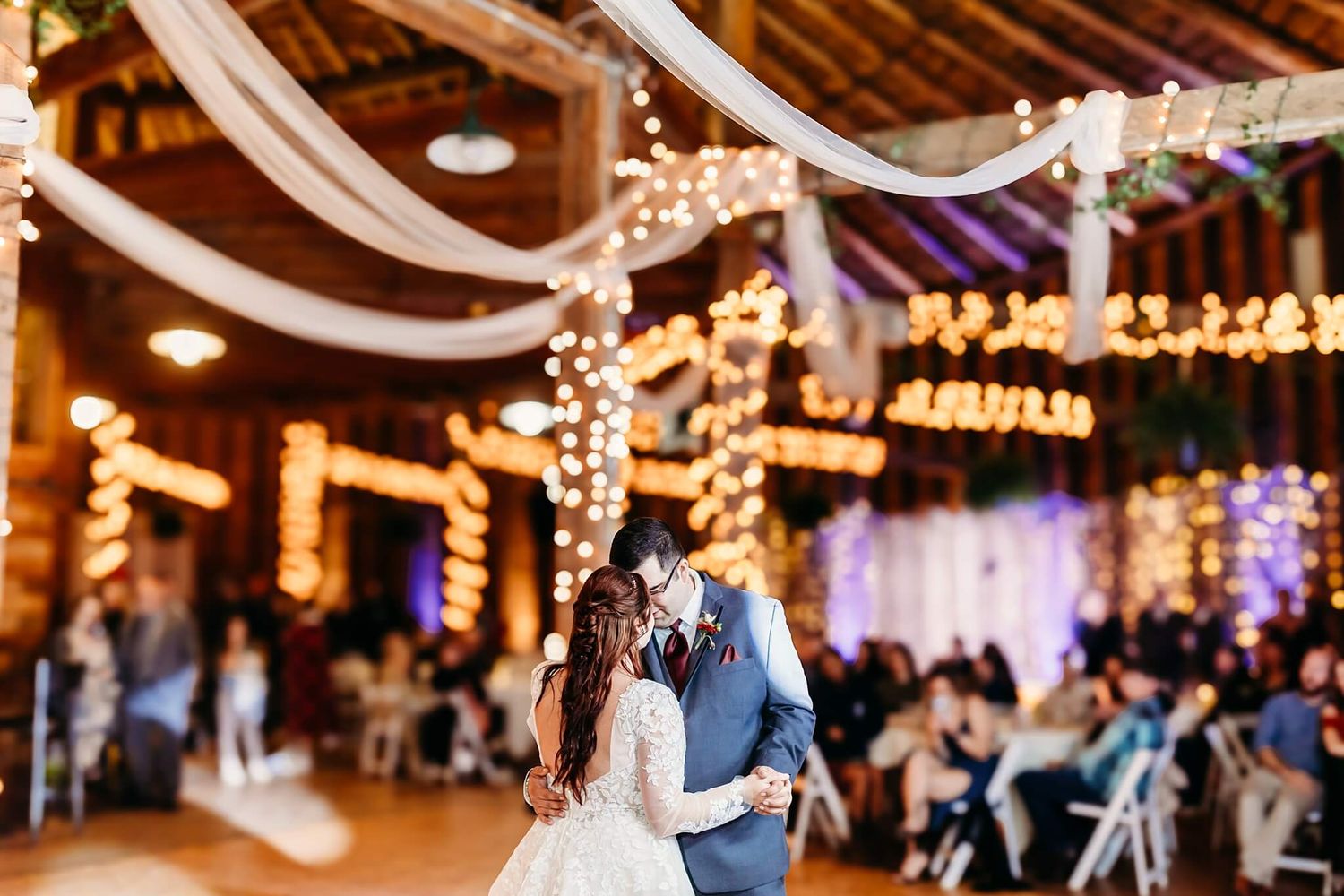bride and groom sharing their first dance in a wedding barn venue