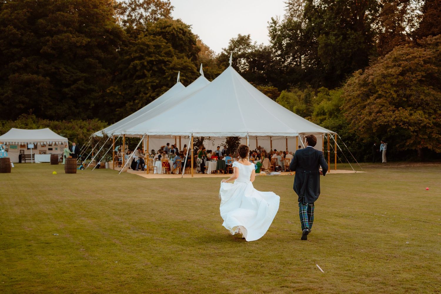 Couple dancing at sunset in garden with golden backlight creating romantic silhouettes.