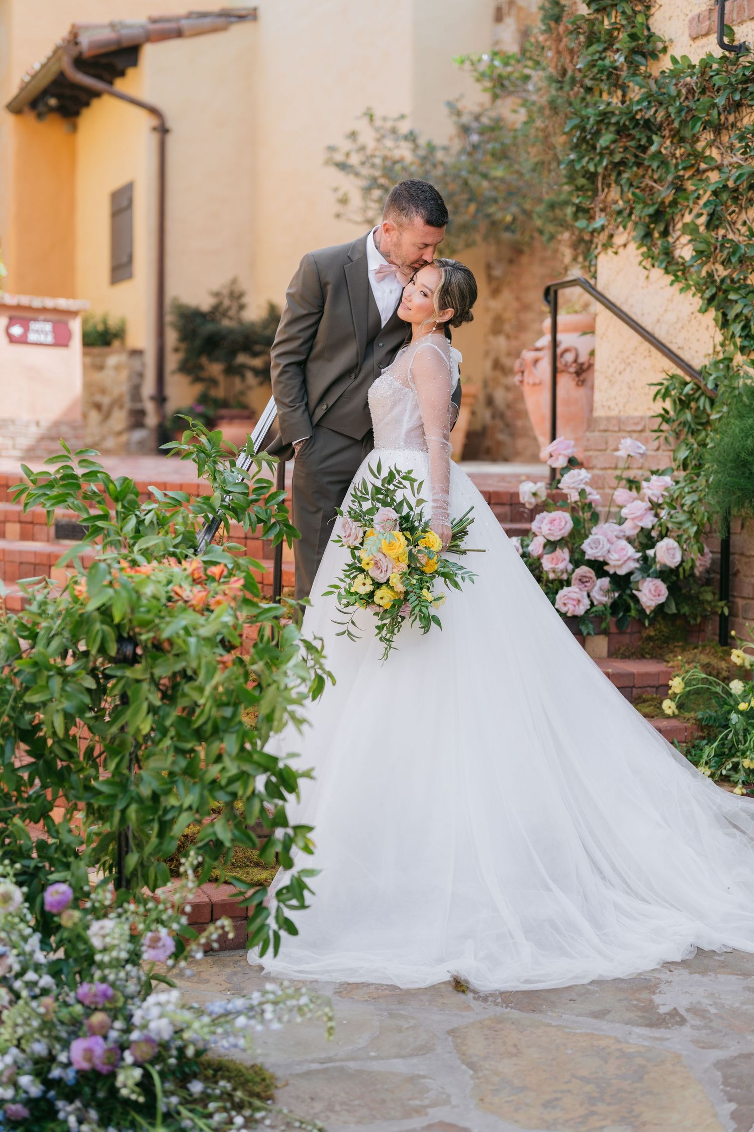 Romantic garden wedding scene with couple embracing among lush greenery. Vancouver wedding photographer and Fraser Valley weddings