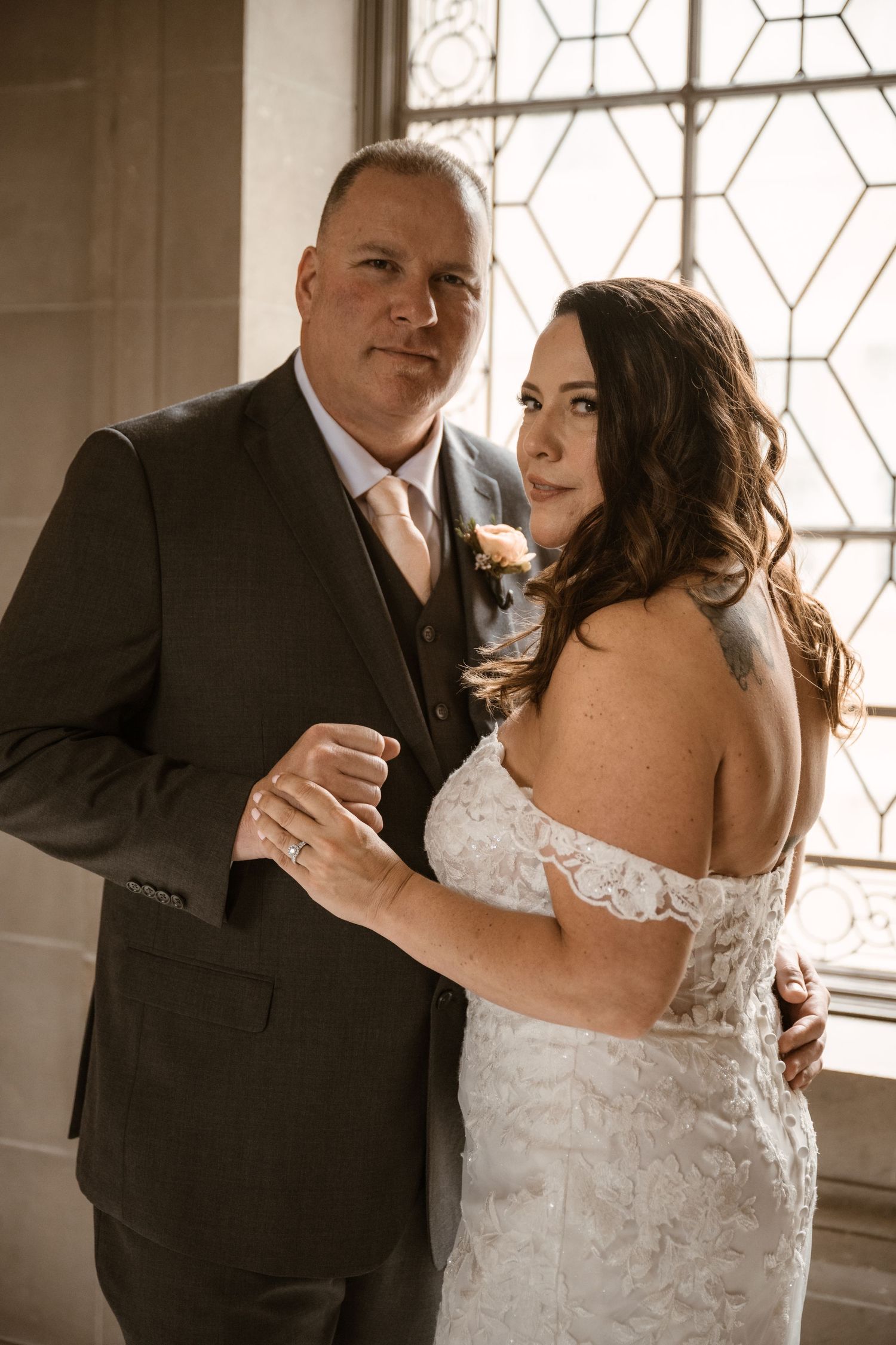 Wedding couple dances and laughs together in warm natural light.