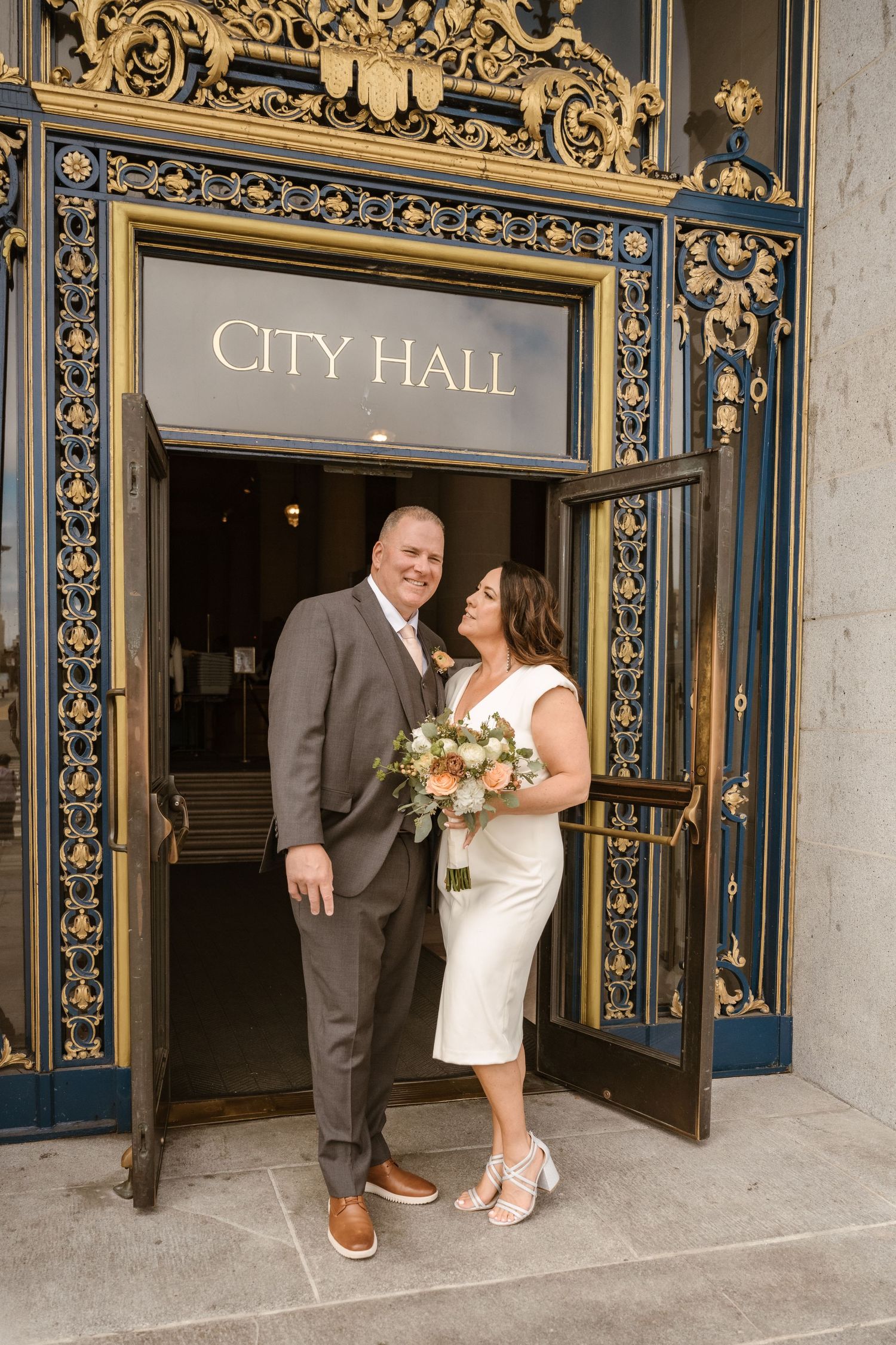 A romantic wedding photo sequence showing a couple sharing intimate moments outside an ornate City Hall entrance.