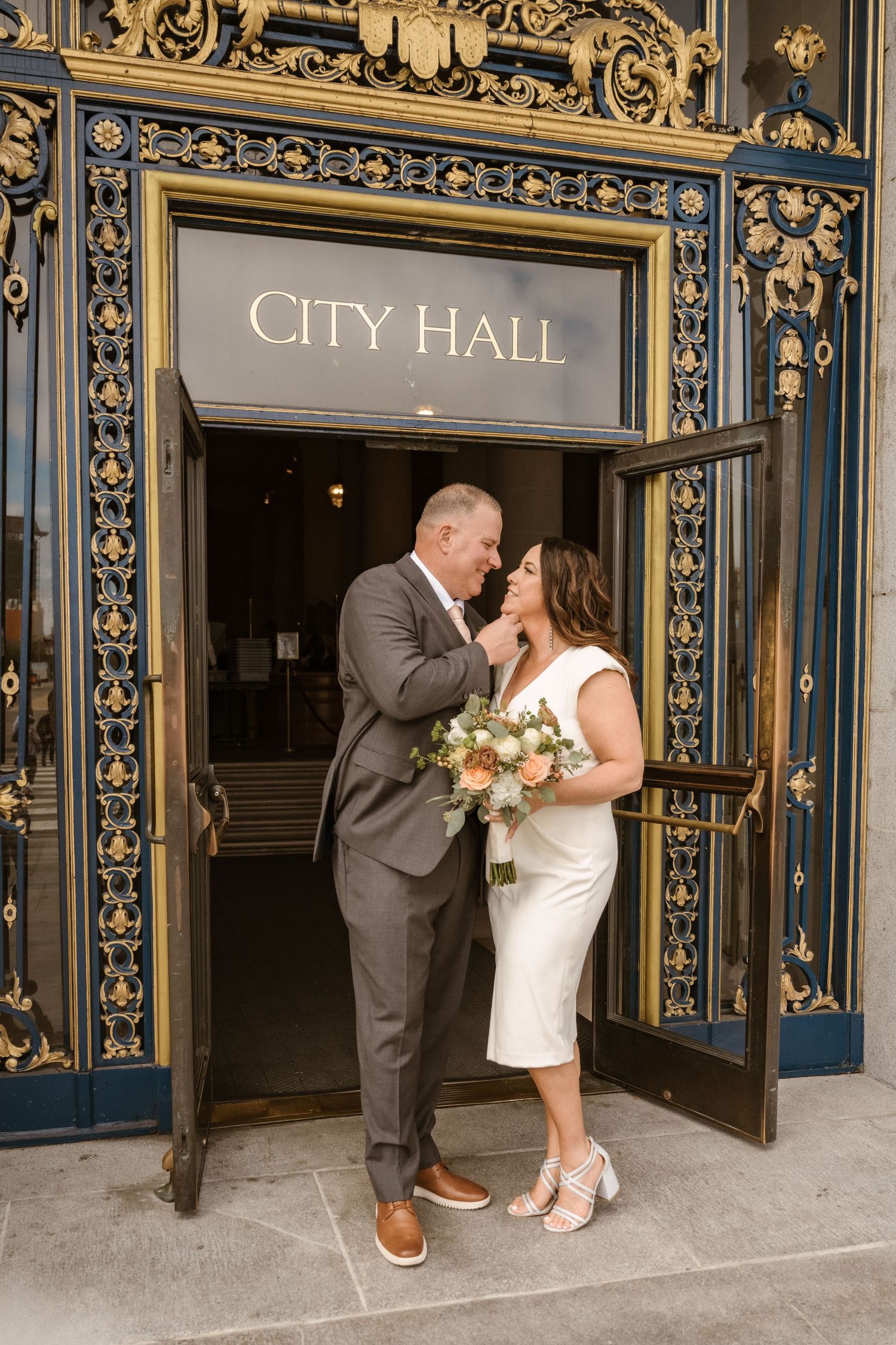 A series of candid wedding photos capturing a couple's joyful moments at City Hall's decorative entrance.