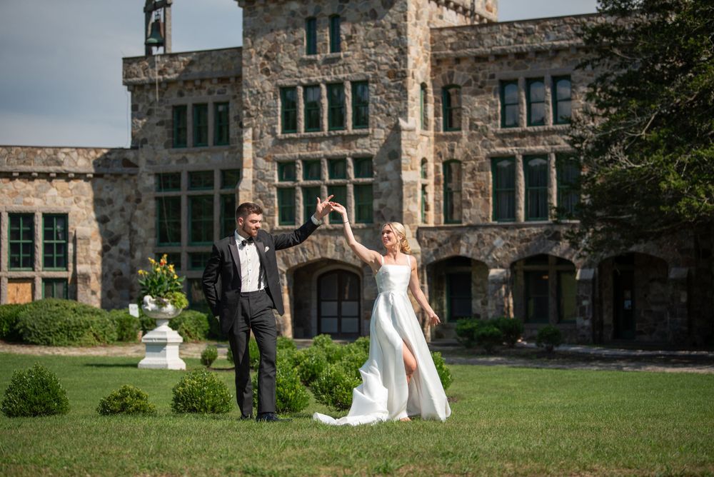 Wedding celebration with dancing couple on grounds of grand stone building.