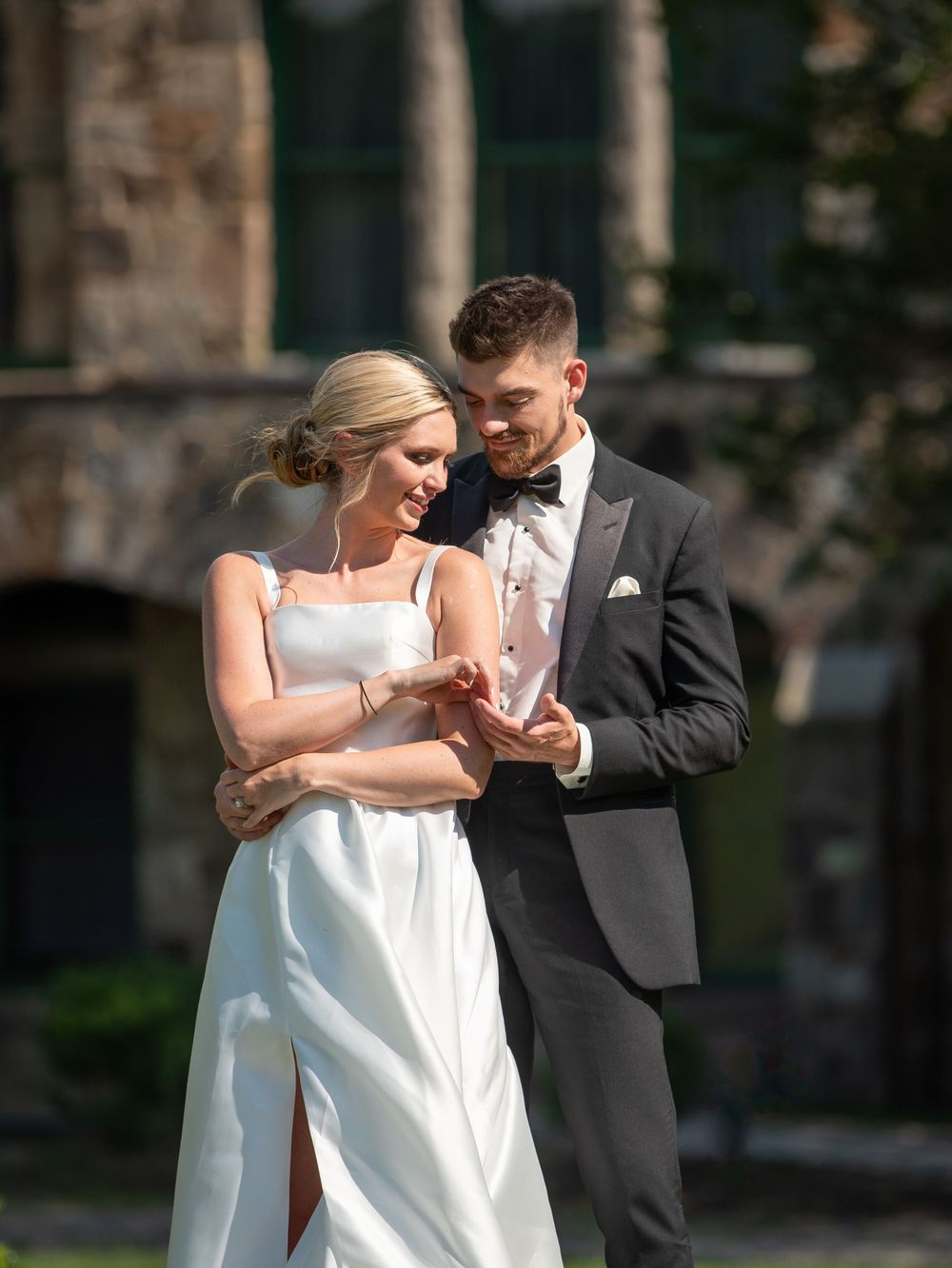 Couple shares intimate dance moment outside stone mansion.