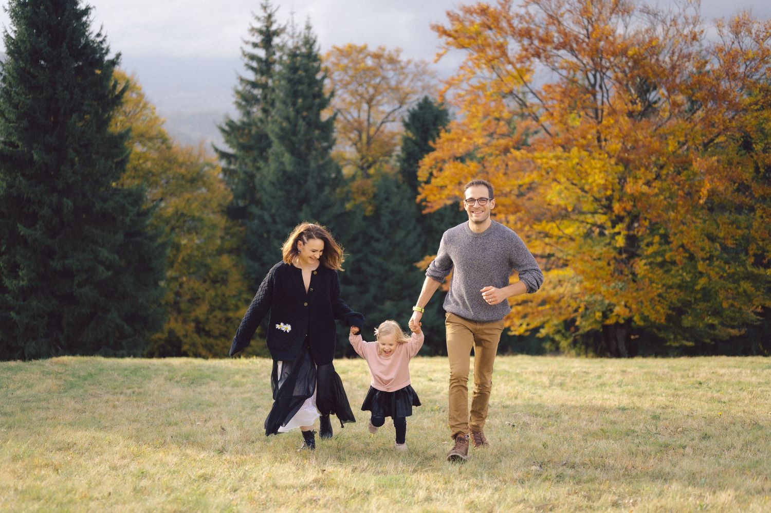 A playful autumn scene in a meadow with colorful fall foliage in the background.