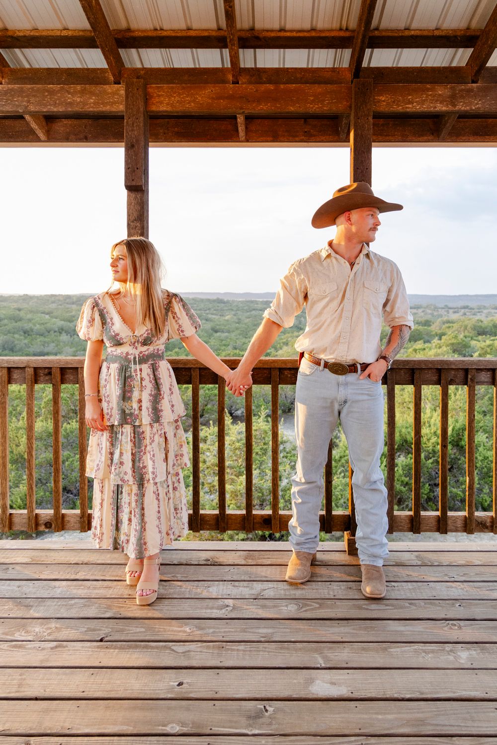 Cowboy hat styled engagement portraits with rustic hill country backdrop in Dripping Springs, Texas.