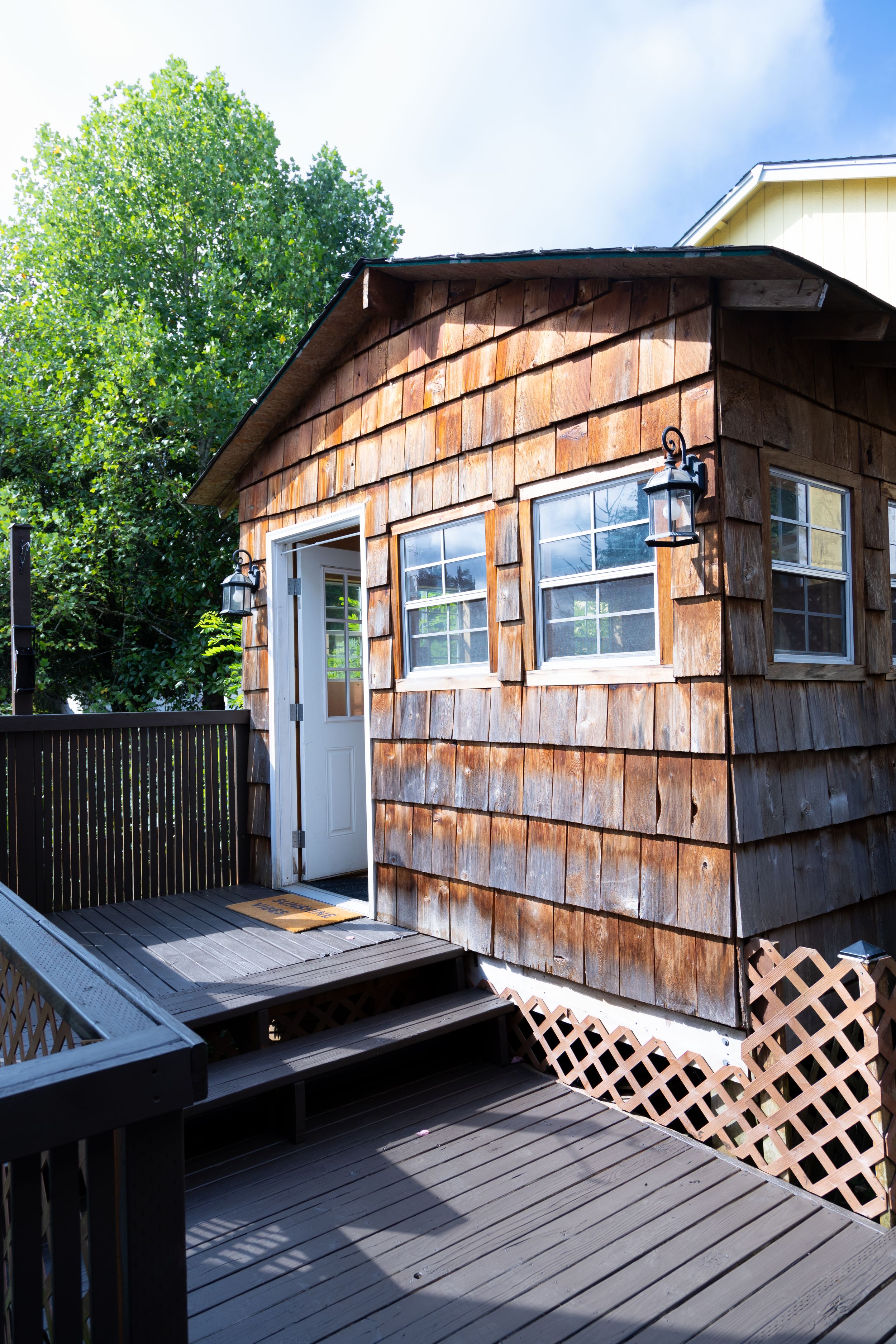Wooden deck with lattice skirting and cedar siding exterior of a residential home.