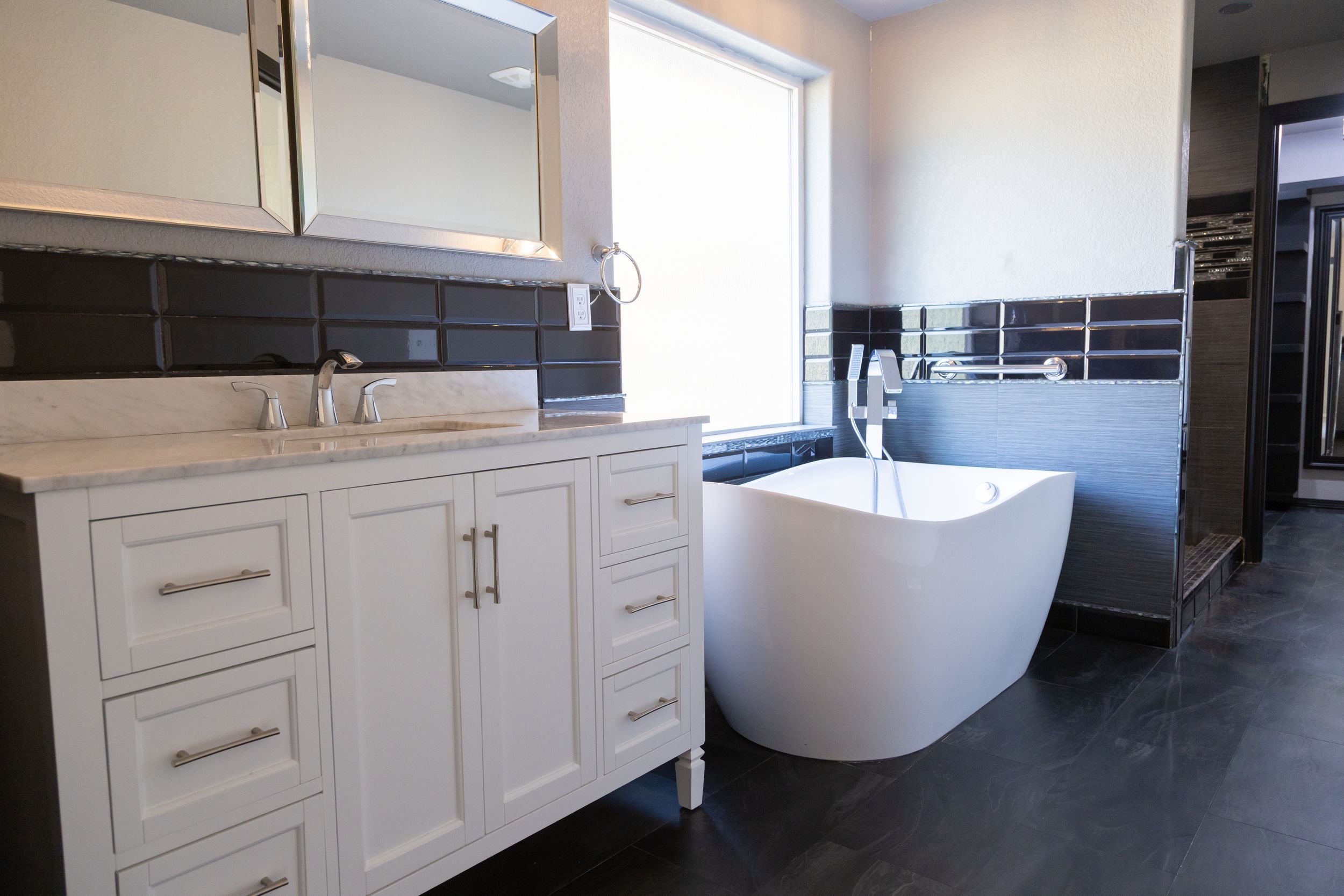 Modern white kitchen featuring sleek cabinetry, stainless steel appliances and a large center island.