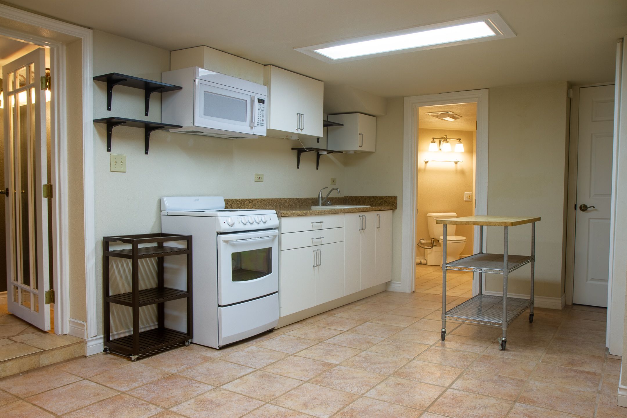 A composite view of empty kitchen and basement spaces showing white appliances and bare walls in residential settings.