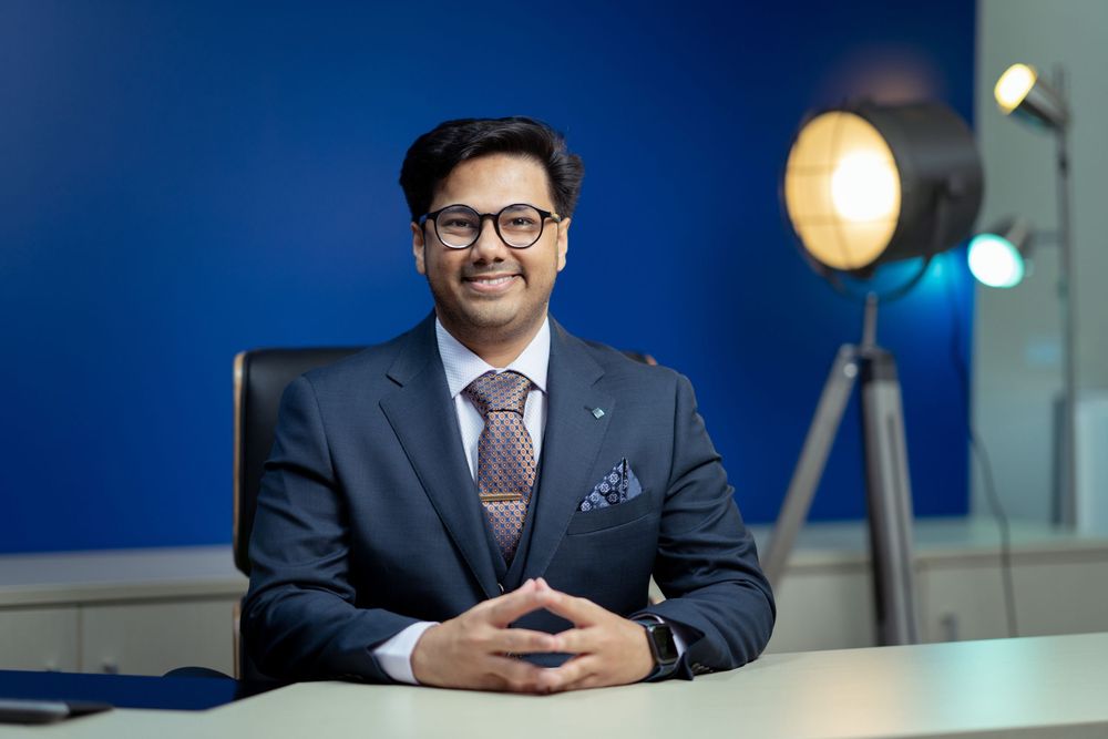 Professional business setting with dark blue walls and modern office lighting fixtures.