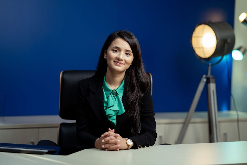 Team members gathered in a bright office workspace with yellow pendant lighting.