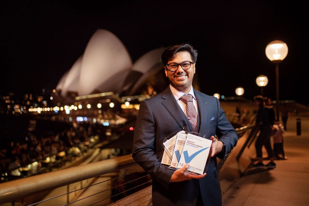 Professional holds a business report in front of city lights on a rooftop terrace at night.