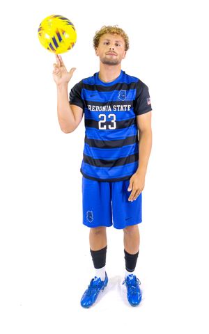 Soccer player in Fredonia State striped jersey poses with yellow ball.