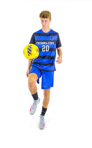 Fredonia State player number 20 in striped jersey walking with yellow soccer ball.