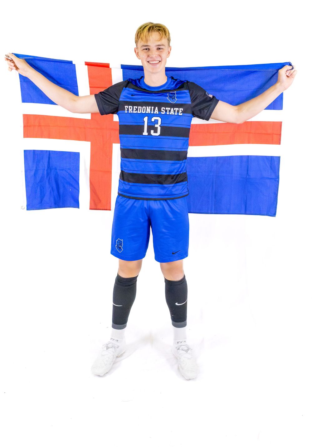 Soccer player in striped uniform holding Iceland flag against white background.