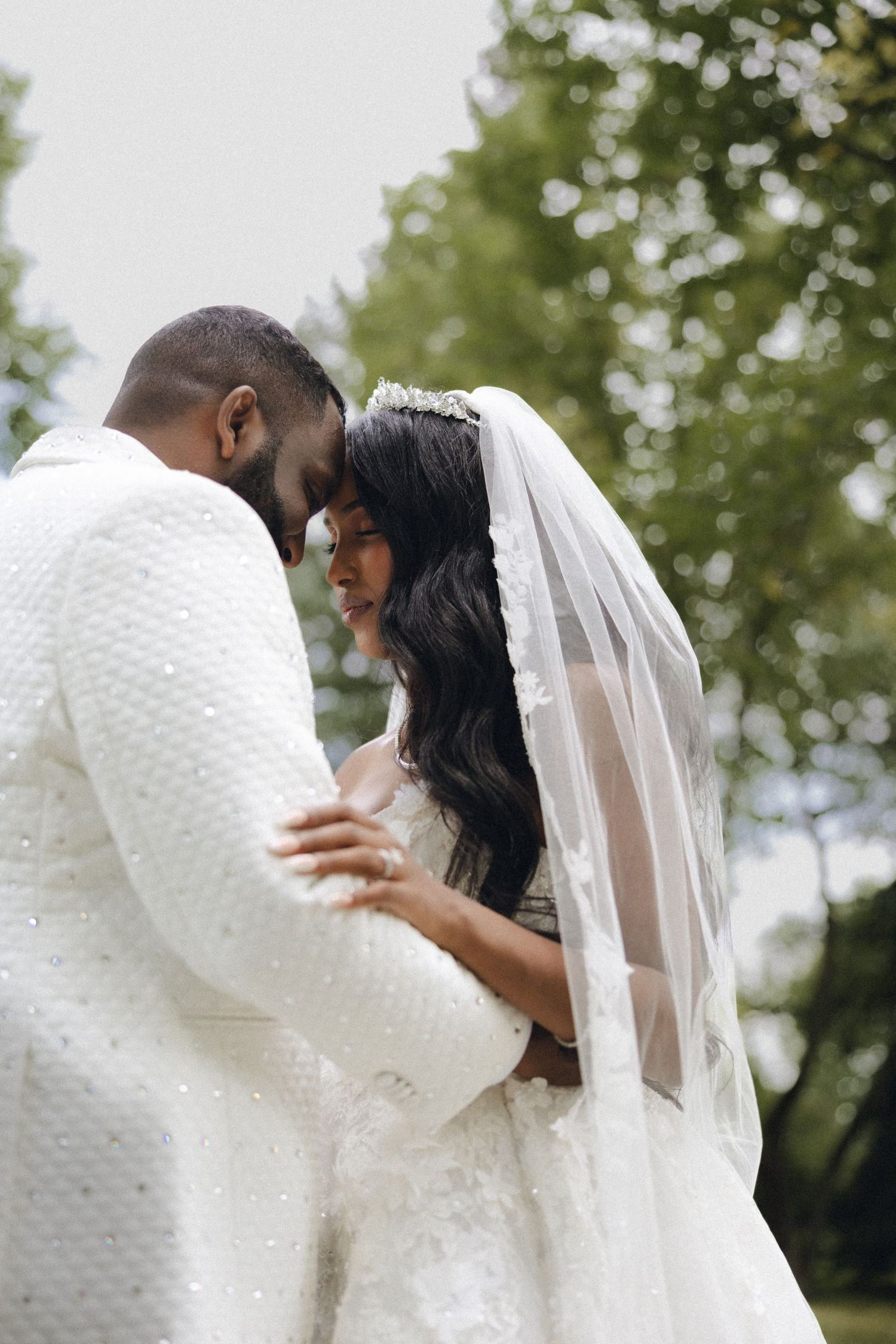 A couple shares an intimate dance moment outdoors with bride in long veil and white dress displayed in sequence.