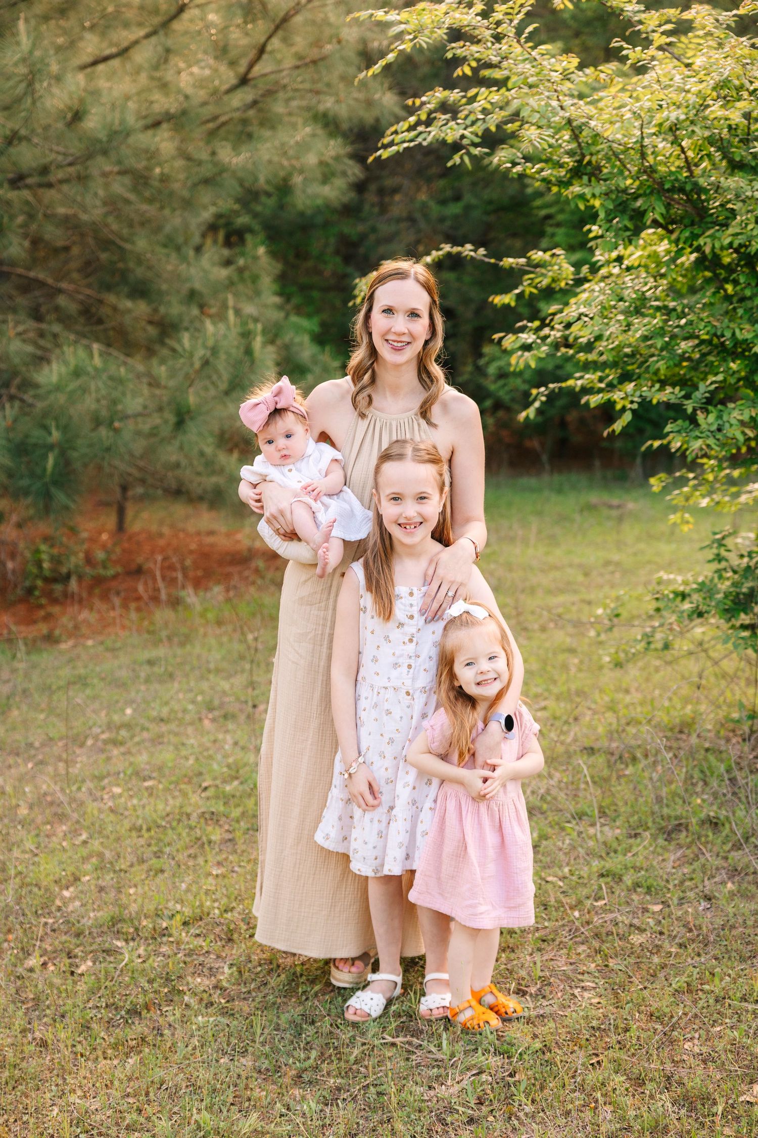 A series of family portraits taken outdoors in a wooded area with natural fall foliage in the background.