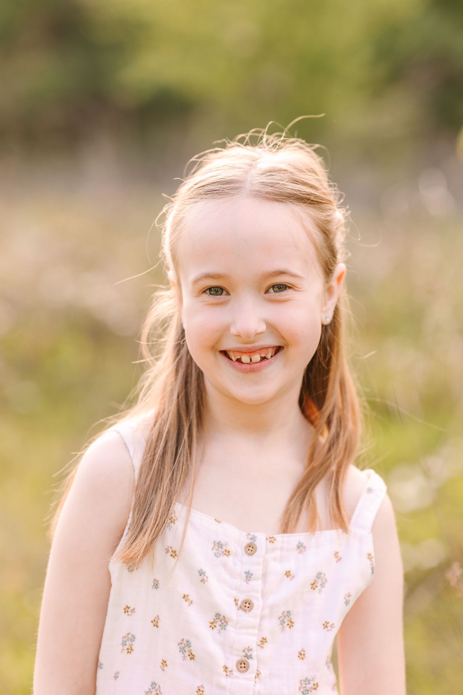 Three warm outdoor portraits of a child in a floral dress smiling at the camera with natural lighting and blurred background.