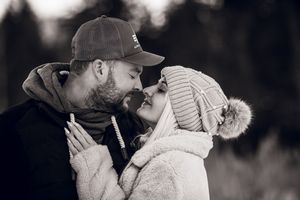 A series of loving couples share tender kisses and embraces in black and white candid photos.