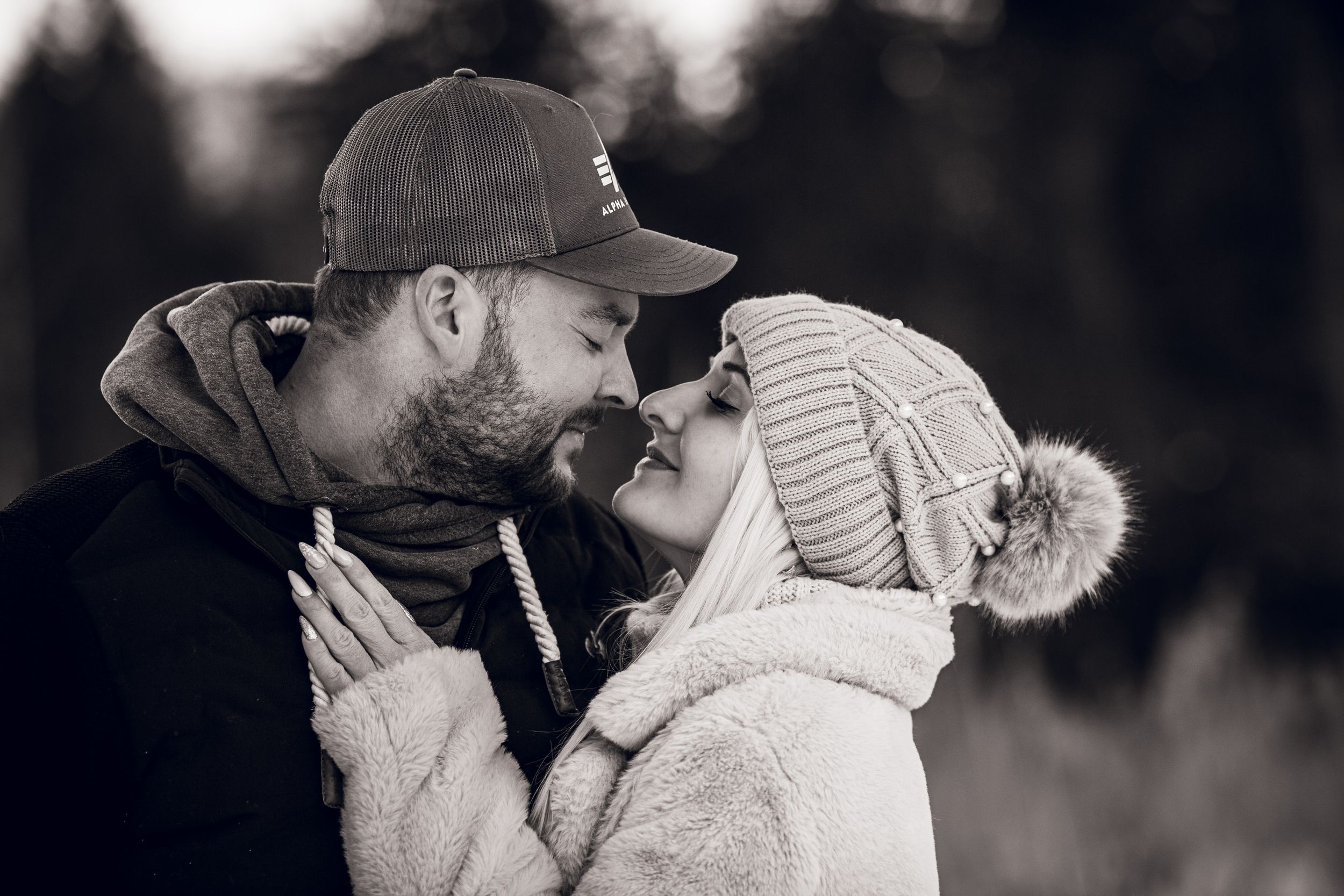 A series of loving couples share tender kisses and embraces in black and white candid photos.