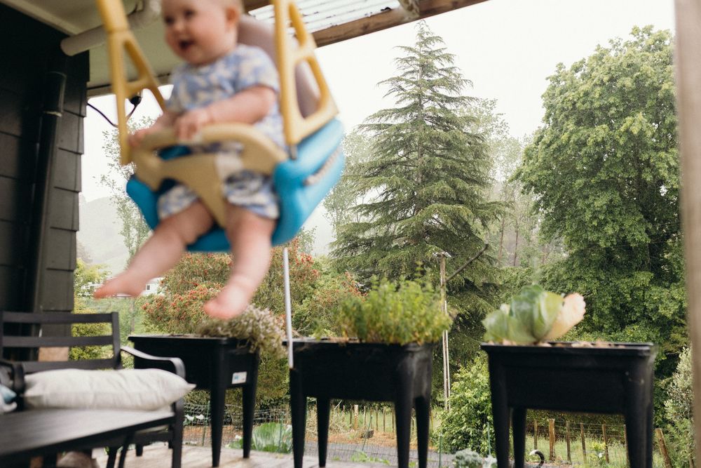 Multiple snapshots showing a child swinging and playing outdoors with trees in the background.