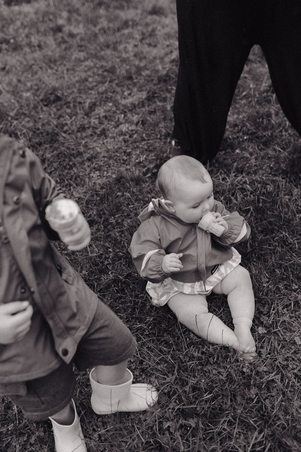 Black and white photo sequence showing movements of a toddler crawling on grass.