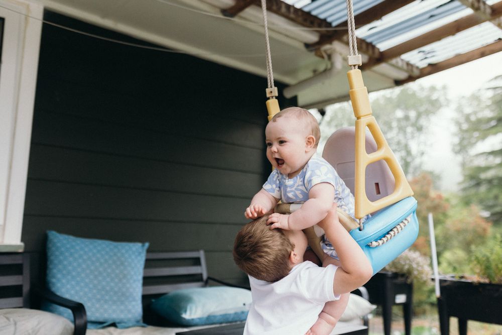 A playful scene of kids enjoying themselves on a covered outdoor porch area.