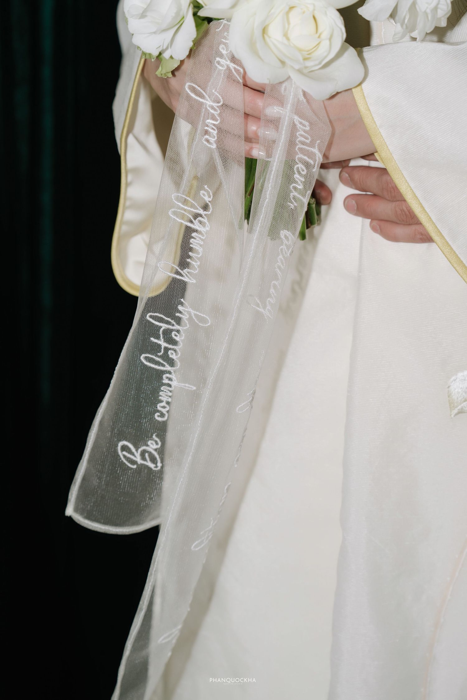 Wedding bouquet ribbon with script text reading Be completely humble and gentle patient bearing.