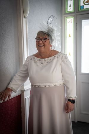 A series of images showing someone in a white lace-trimmed dress smiling and posing near a window in different angles.
