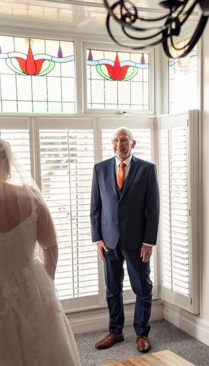 A sequence of four photos showing a suit-clad figure standing in front of white shuttered windows with stained glass accents.