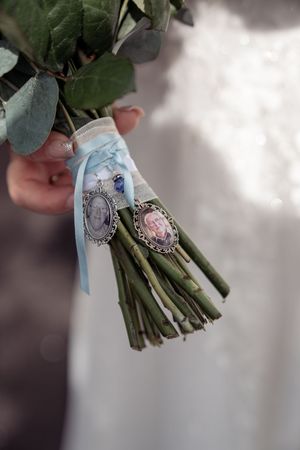 Wedding bouquet stems wrapped with delicate lace and vintage brooches for a romantic heirloom touch.