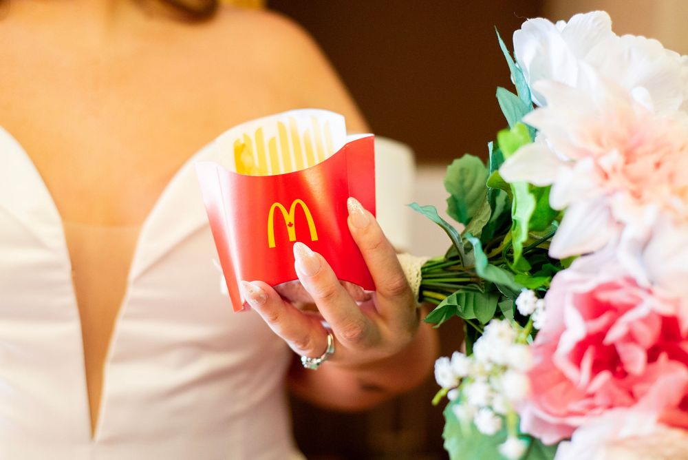 Wedding reception details showing McDonald's french fries and pink floral decorations.