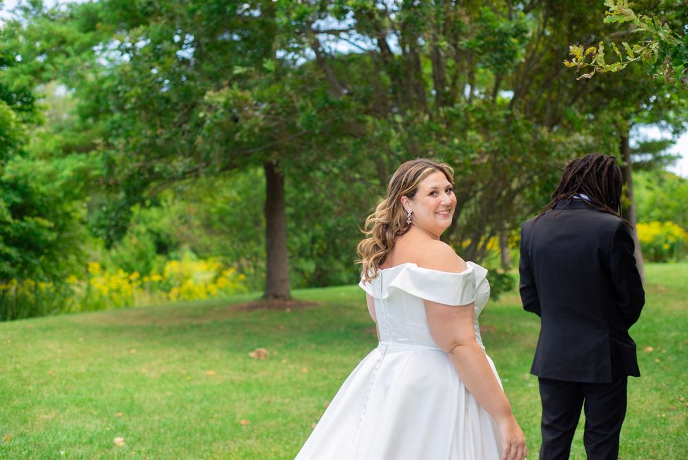 Newlyweds posing together in a scenic outdoor garden setting for wedding photos.