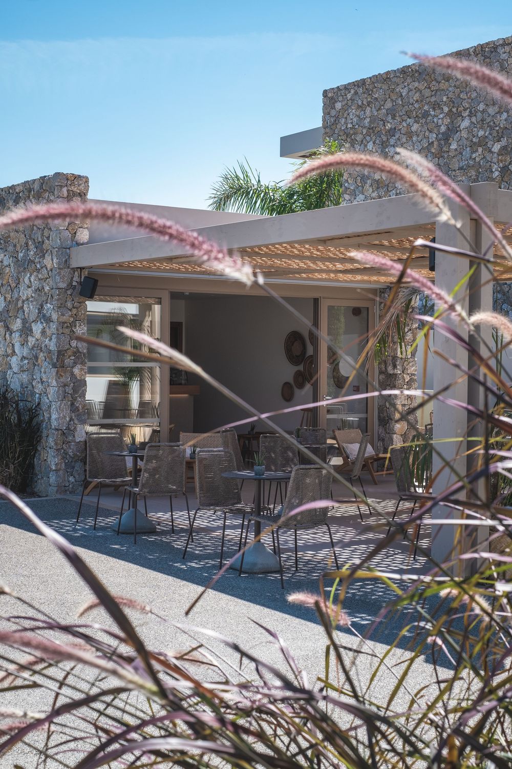 Stone-walled patio area with covered seating and decorative landscaping at an upscale resort.