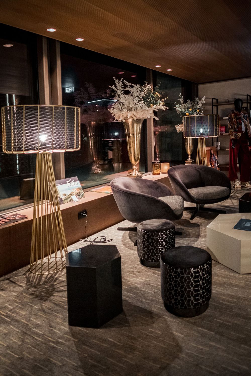Modern luxury lounge interior with designer lamps, plush seating, and elegant floral arrangements.
