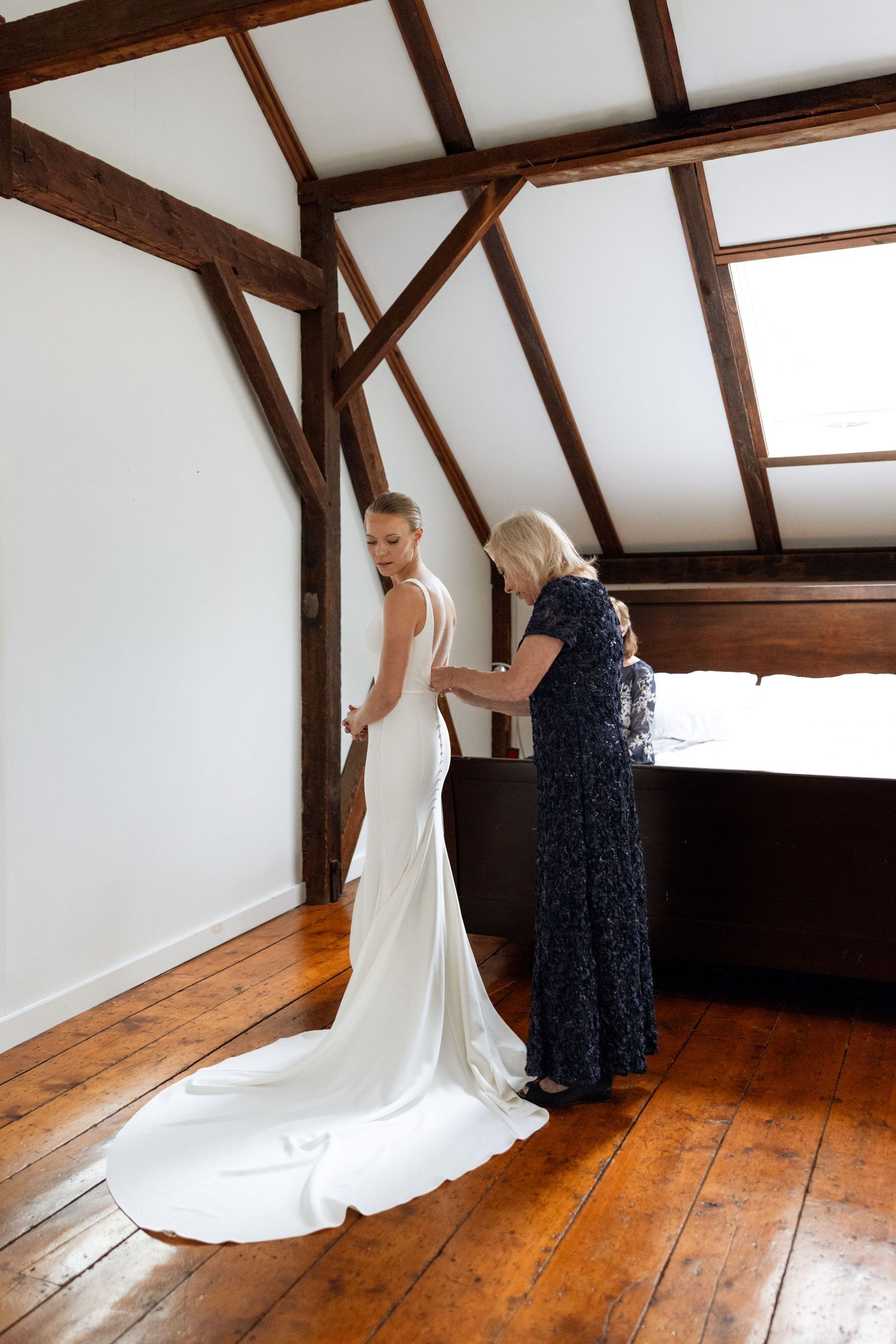 Wedding dress fitting sequence in a rustic room with exposed wooden beams.