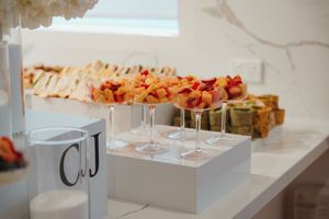 White paper food box with colorful garnishes and toppings arranged in a line on a light colored surface.