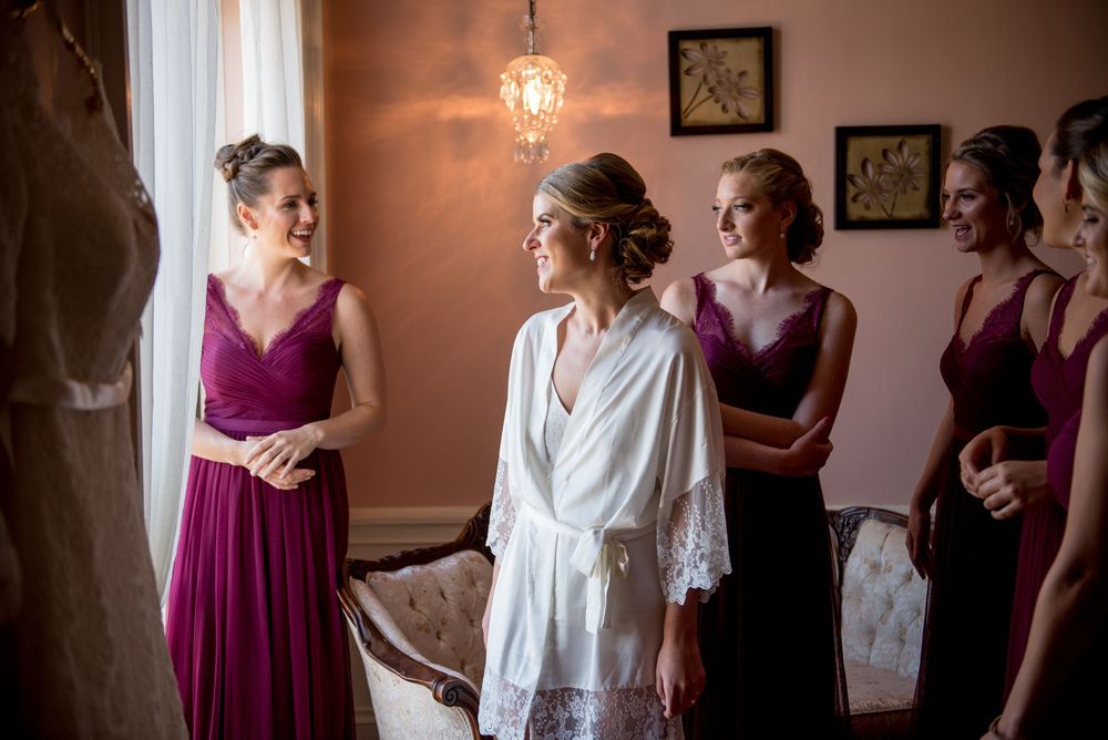 Bridal party gathered in a warm-lit room preparing for the ceremony.
