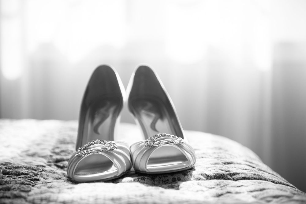 Elegant bridal shoes photographed in soft focus with dreamy lighting.