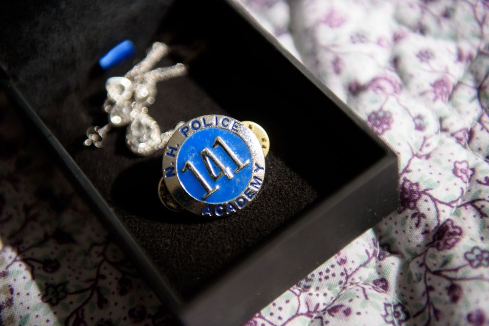 Wedding rings and jewelry displayed on floral patterned fabric.