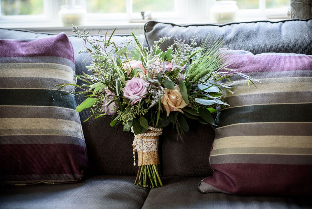 Wedding bouquets and floral arrangements on cushioned window seating.