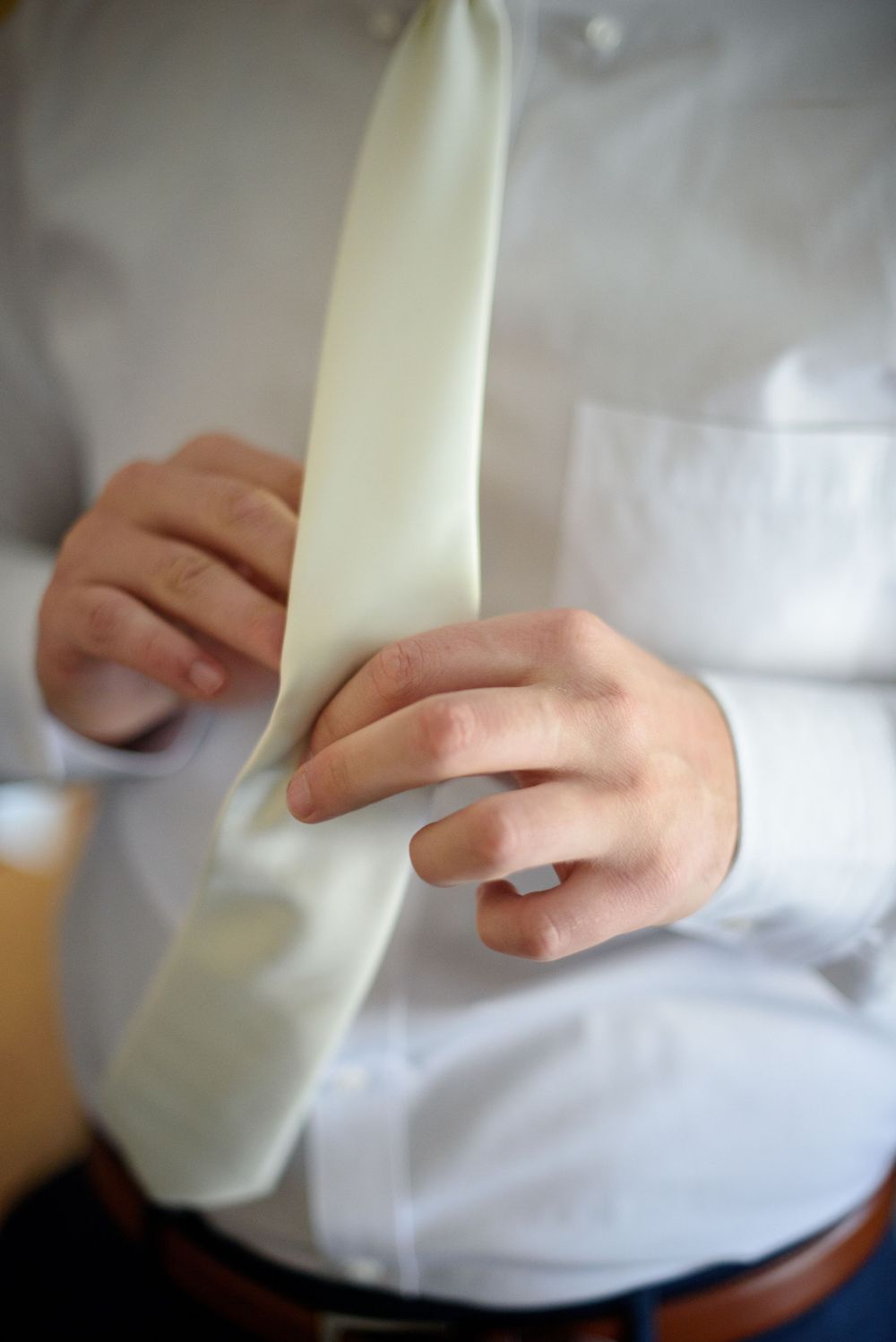 Close up detail shots of someone adjusting a white collar or garment.