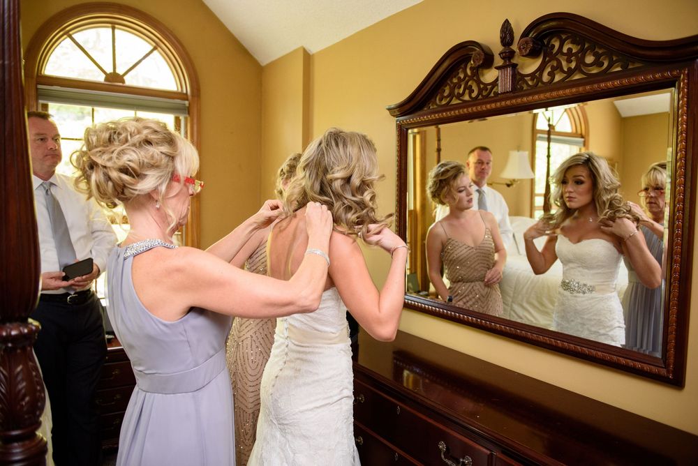 Interior scene with arched window and ornate mirror reflecting formal preparations.